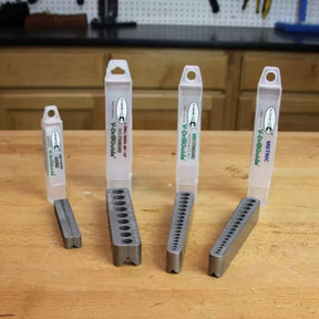 Four V-DrillGuide drill guides in various sizes on a woodworking bench