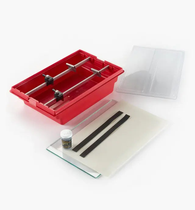 Woodworking blade sharpening jig kit with red tray, guide rods, and accessories on white background