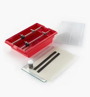 Woodworking blade sharpening jig kit with red tray, guide rods, and accessories on white background