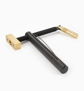 Woodworking jig with black handle and brass fittings on white background