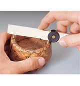 Woodworker using depth gauge on spalted wood bowl for precise measurement