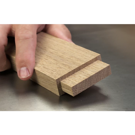 Hand holding a wooden tenon joint, woodworking joinery detail on table saw.