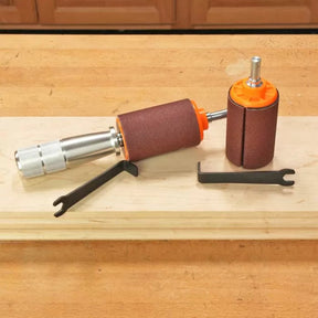 Drum sander kit with sanding drums and wrenches on a wooden workbench