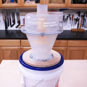 Quick-Snap dust separator cyclone lid on bucket in woodworking shop, tools in background