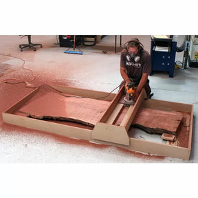 Woodworker using router sled to flatten live edge slab with power tool in workshop