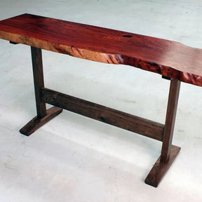 Live edge wood console table with natural grain and sturdy wooden legs on a light floor