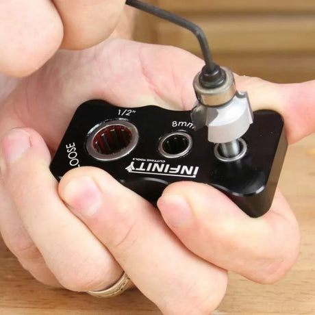 Person using a router bit bearing removal tool for woodworking on a wooden surface