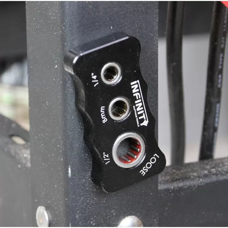 Black woodworking router collet wrench with three size holes mounted on metal frame