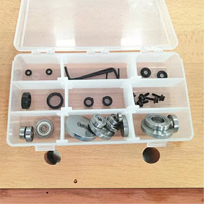 Woodworking router bit bearing and screw set in plastic organizer on wood table