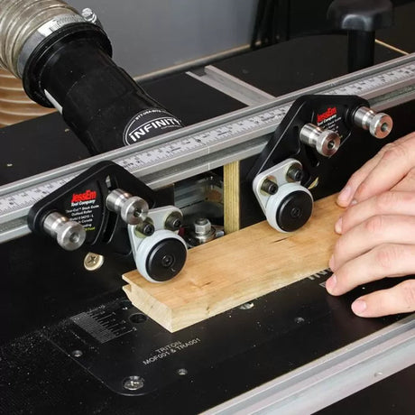 Woodworker using router table fence and stock guides to shape wood for precise woodworking