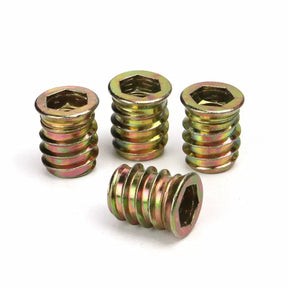Four hex drive threaded brass wood inserts for woodworking on white background