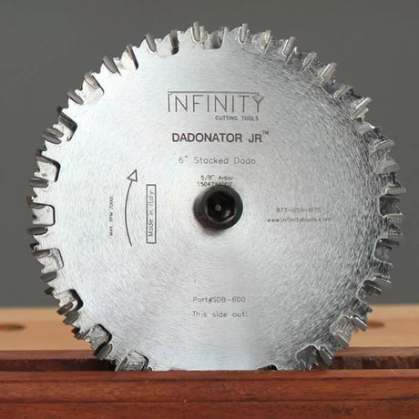 6-inch stacked dado saw blade with carbide teeth on a wooden surface, labeled Dadonator Jr.