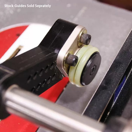 Close-up of a router table stock guide wheel and mounting bracket for woodworking