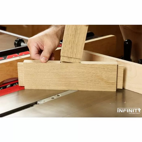 Woodworker using a table saw jig to cut precise joints in a wooden board